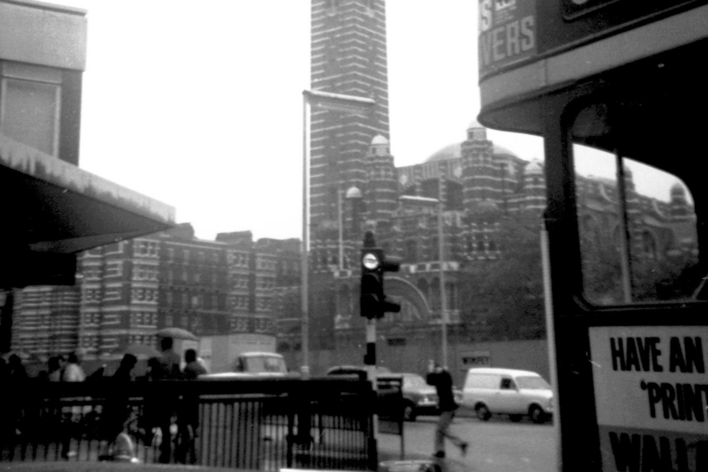 1971年的 Westminster Cathedral 街景,前方可見巴士、行人、交通燈和欄杆。